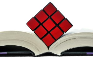 © Vlue | Dreamstime.com - Rubiks Cube On Open Book Photo